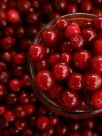 Close-up of vibrant cranberries in a glass bowl, perfect for healthy recipes.